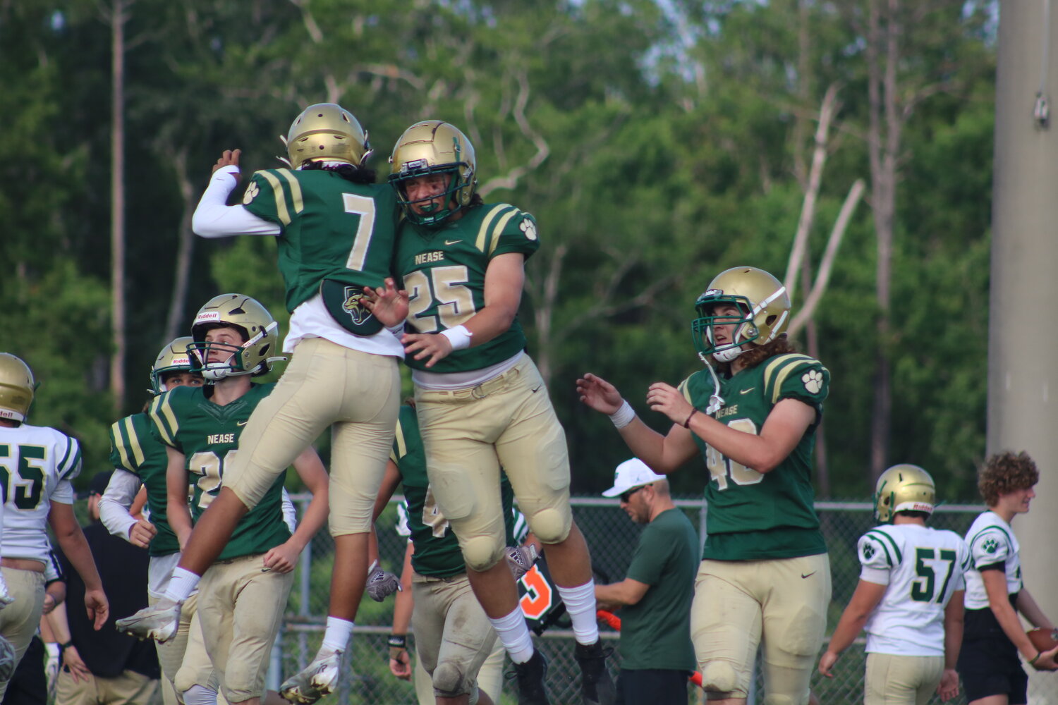Nease football players on the green team celebrate following a turnover forced by the defense during the green and gold game at Panther Stadium May 12.